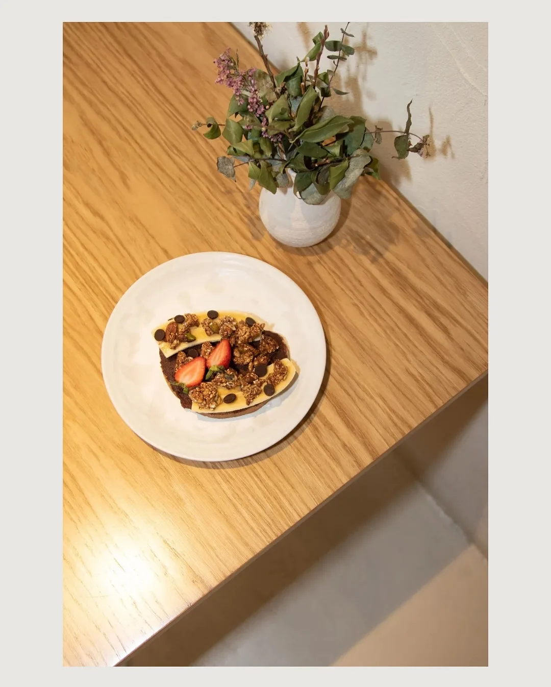 Desayuno y flores sobre una mesa de madera